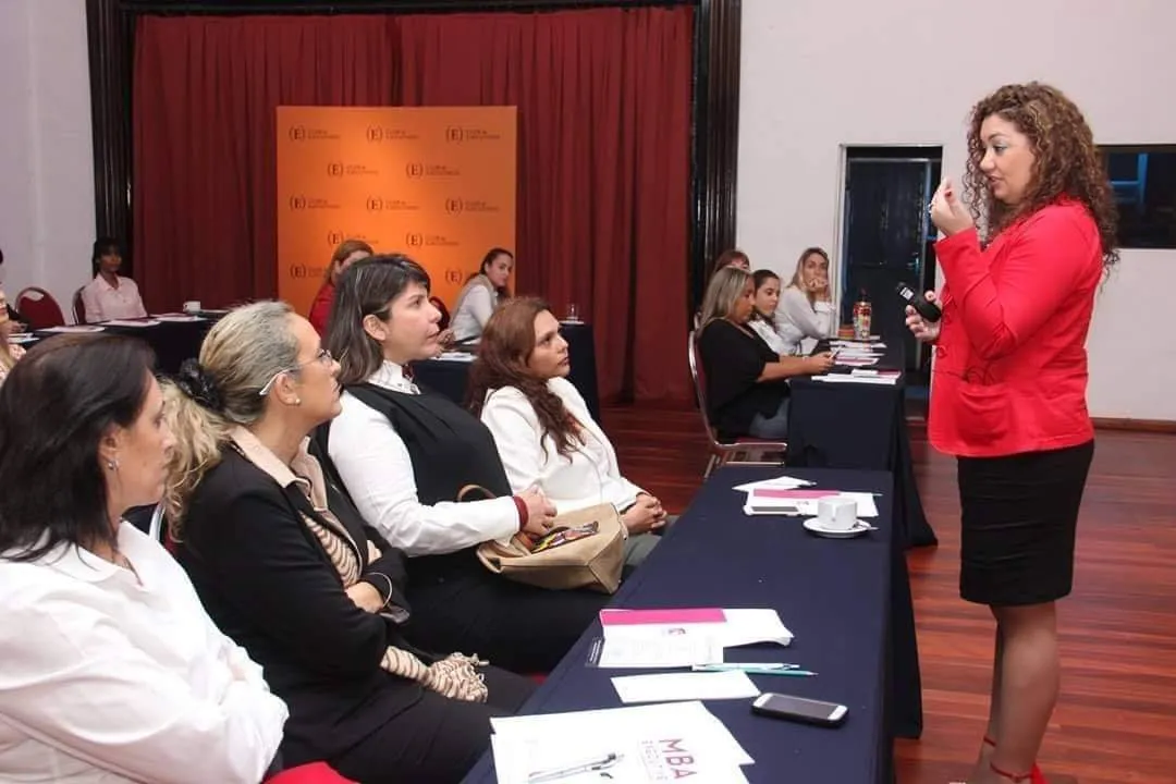 Leticia Centurión conversando con participantes de un taller, representando el programa de Inteligencia Emocional para Líderes